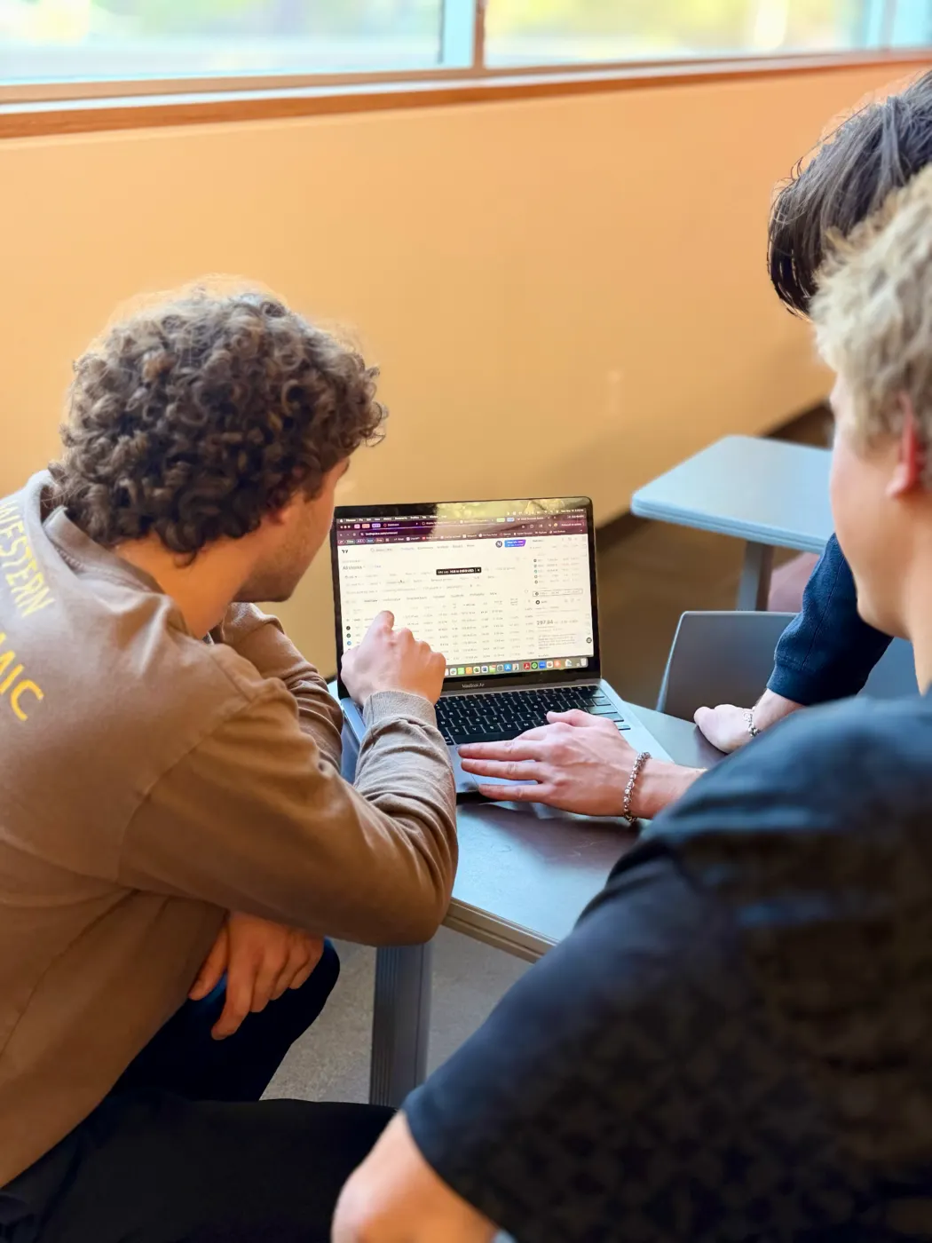 Students reviewing financial information on a laptop during a workshop